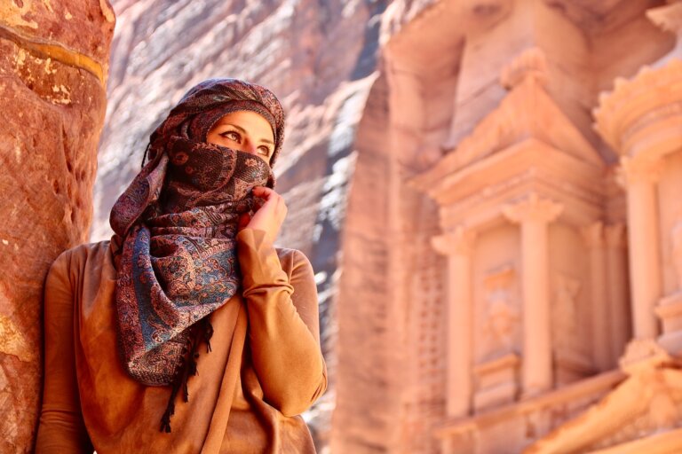 Petra - Woman in brown hijab standing near brown concrete building during daytime