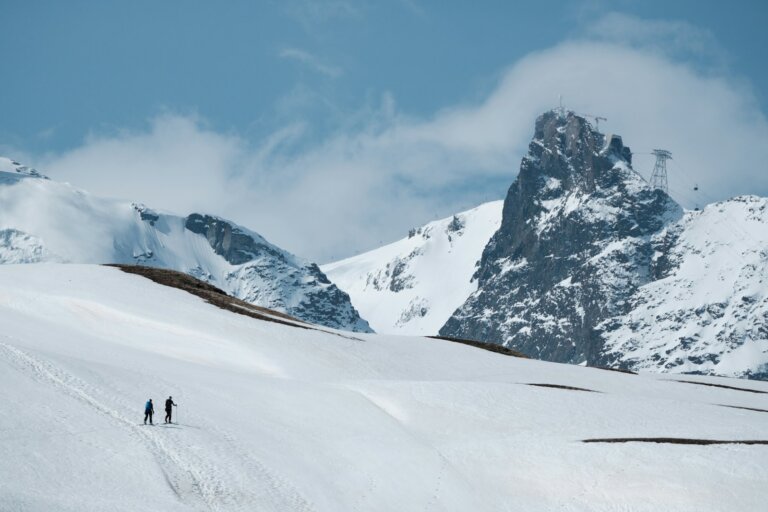 a couple of people skiing down a snow covered slope