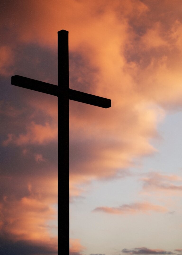 silhouette of large cross under orange sky